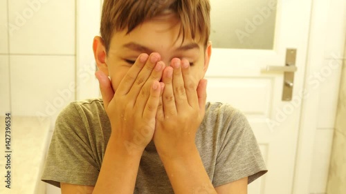 Boy is making morning routine - washing face