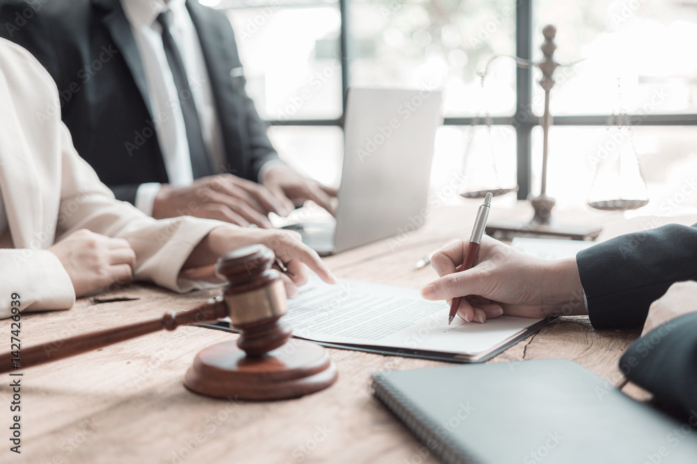 Lawyer team presenting signed contract document to client in office. Law, judge, court, law concept. Judge's gavel with scales of justice. Close up.