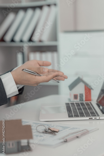 Obraz na płótnie Real estate businessman presenting home loan and presenting house to customer after discussing and signing contract with approved application. Close up. w salonie