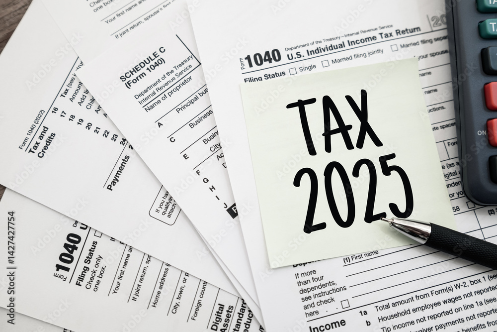 Obraz premium Text Tax 2025 on the note paper with calculator and taxes documents. Business and Annual tax concept..