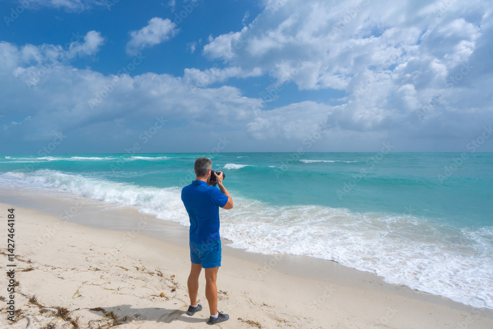 Man photographer with a camera on vacation. Summer photographer by the ocean. Tropical travel photography. Photograph of a man by the sea. Photographer capturing tropical views. Tourist photographer. Man photographer with a camera on vacation. Summer photographer by the ocean. Tropical travel photography. Photograph of a man by the sea. Photographer capturing tropical views. Tourist photographer.