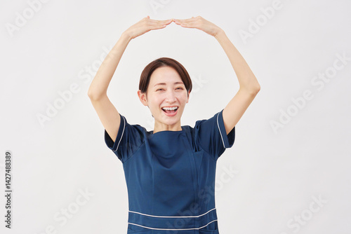 女性　美容看護師　腕で丸のジェスチャー　白背景