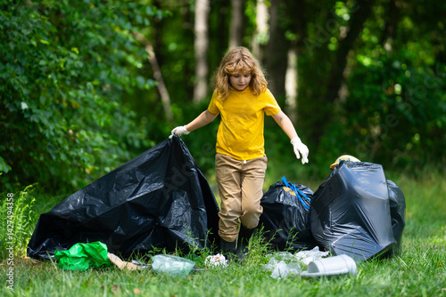 Obraz na płótnie Child picking plastic trash for cleaning the nature. kid Clean up garbage outdoor. Ecology concept. Environment Day. Save earth. Recycling bin garbage. Ecology. Environmental care. Eco kid. w salonie