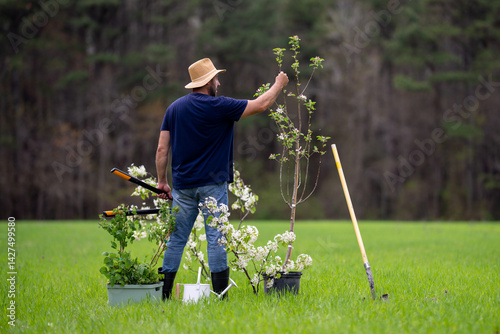 Obraz na płótnie Gardener farmer working in spring garden. Farmer in garden with shovel. Mature gardener cultivating land. Mature farmer in orchard. Worker farmer planting seedling. Growing plants in backyard. w salonie