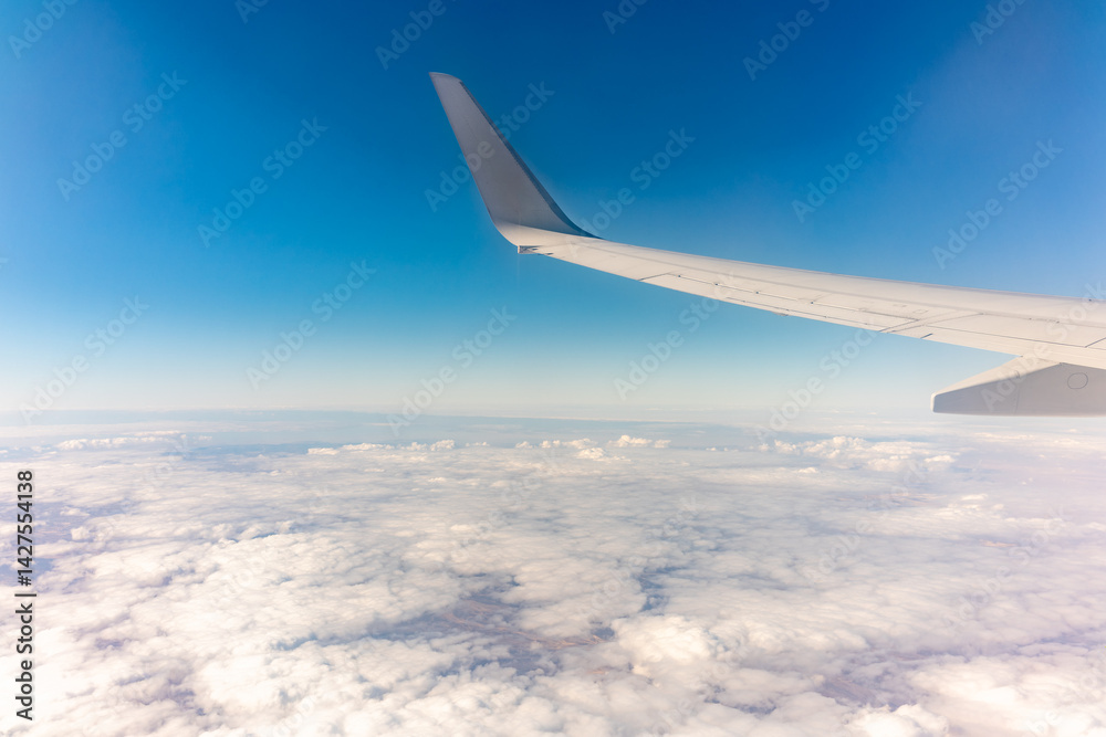 View from the airplane window at a beautiful cloudy sky and the airplane wing View from the airplane window at a beautiful cloudy sky and the airplane wing