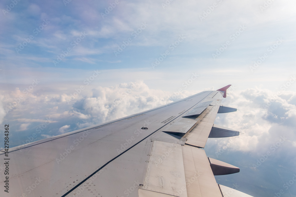 View from the airplane window at a beautiful cloudy sky and the airplane wing View from the airplane window at a beautiful cloudy sky and the airplane wing
