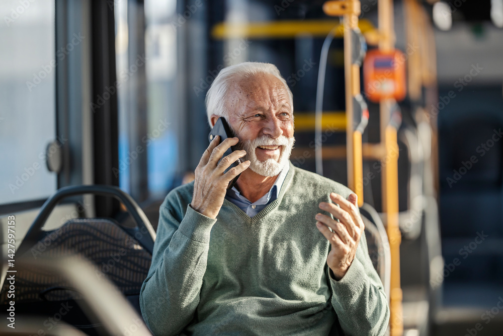 Portrait of happy senior man riding public transportation and talking on his cellphone.