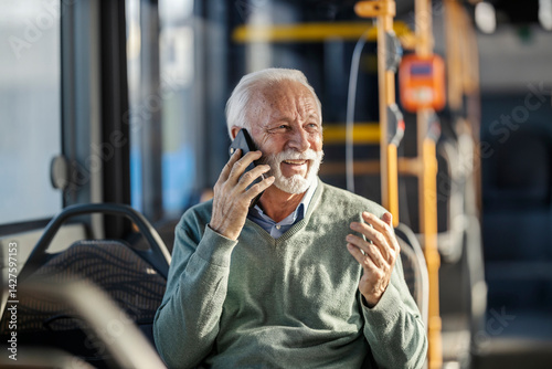 Obraz na płótnie Portrait of happy senior man riding public transportation and talking on his cellphone. w salonie