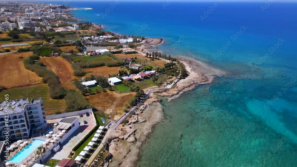 Summer days in Protaras, Cyprus. The camera flies over the turquoise Mediterranean Sea and the beach line surrounded by hotels.