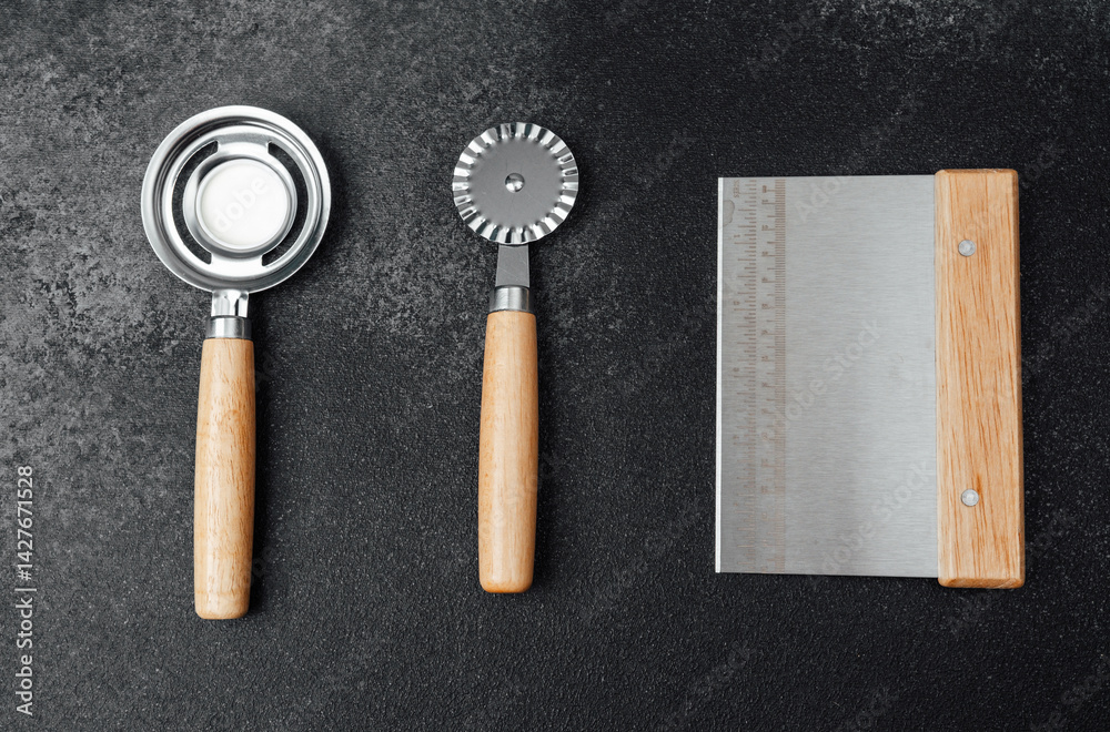Kitchen tools for baking and food preparation on a dark countertop