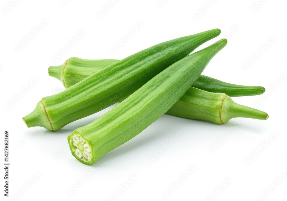 A close up view of several green okra pods stacked upon each other on a plain white background space area A close up view of several green okra pods stacked upon each other on a plain white background space area