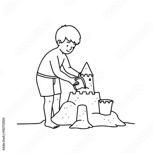 Boy happily building a sandcastle on the beach  