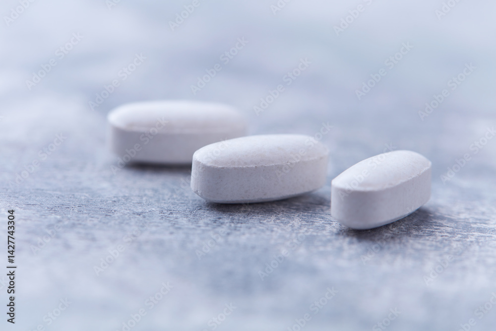 Amino acids tablets on wooden background. Soft focus. Close up	
