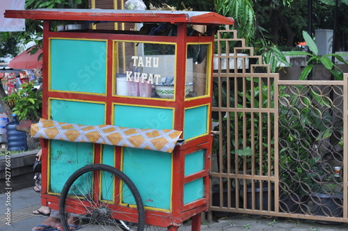 a street cart selling ketupat tahu on the side of the road