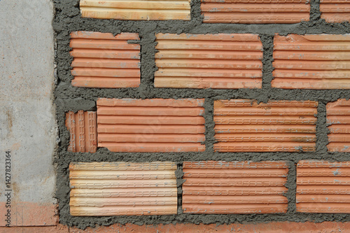 Red brick blocks are built with hands and tools on the building.