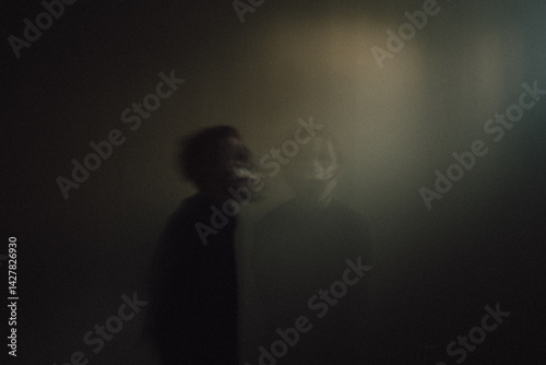 Photography Double exposure of creepy clown boy standing in spooky basement light