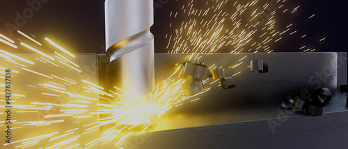 A close up of a drill bit cutting into a piece of metal