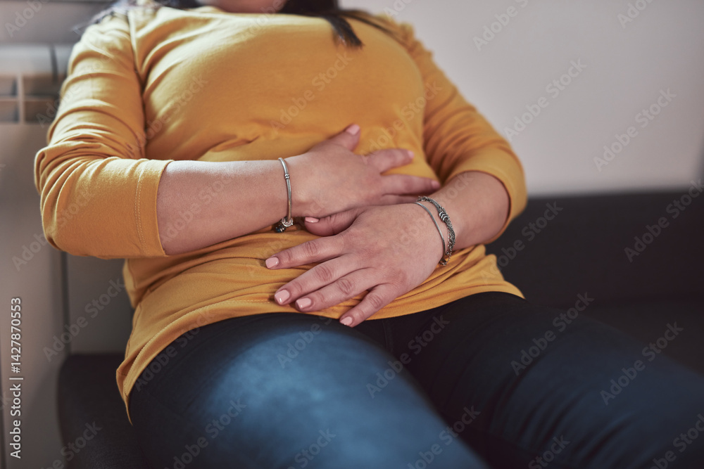 Woman with strong stomach ache, menstrual and digestive issues at home.