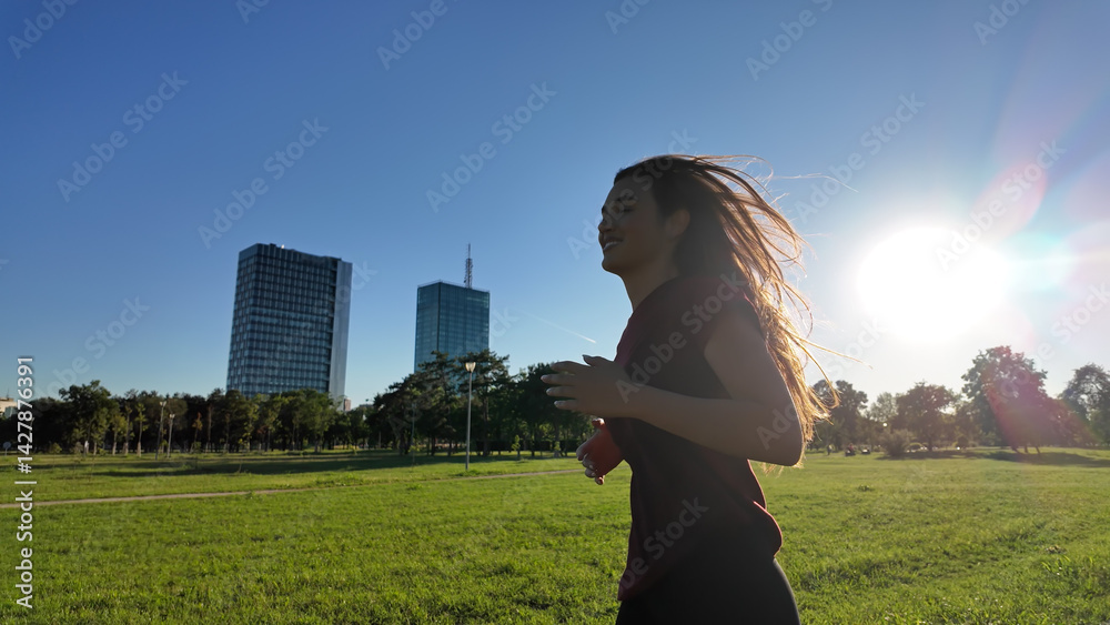 Young woman running and jogging in urban park.