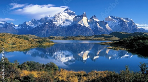 Snow capped mountain range reflects in a serene body of water