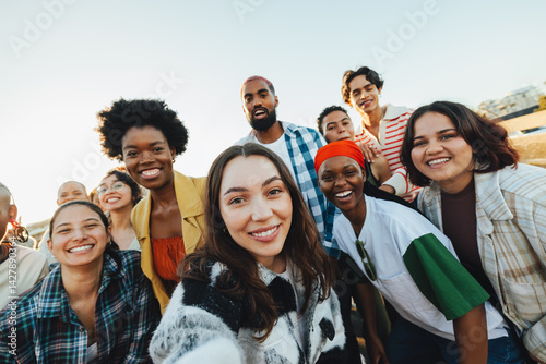 Fototapet Diverse group of friends gathering outdoors while expressing unity and happiness