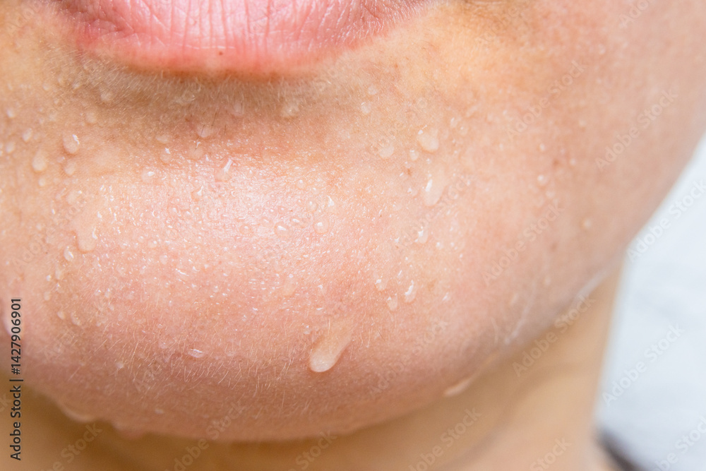 Fototapeta premium Close-up of a woman's face sweating in the hot summer