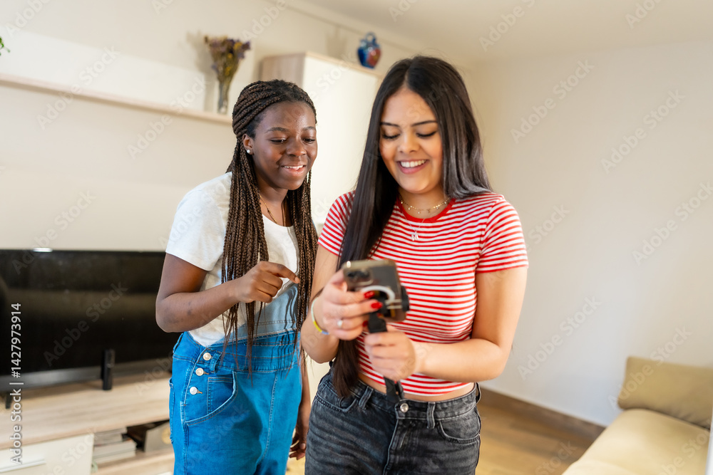 Two teenage girls using smartphone at home