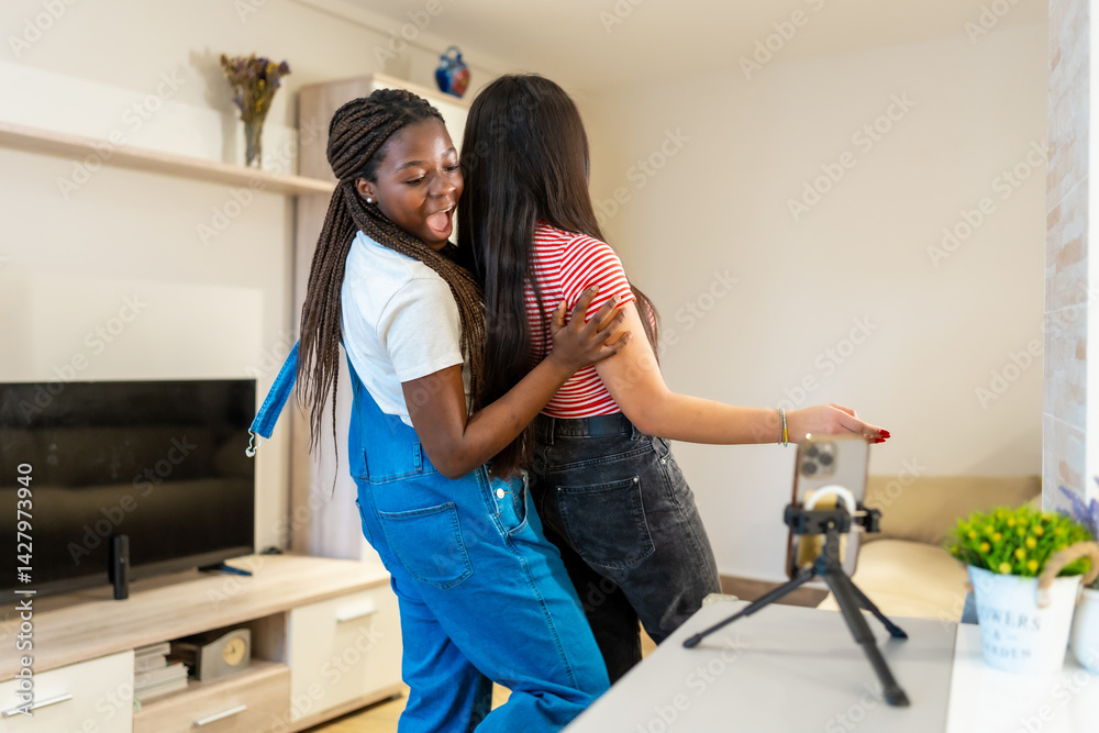 Two cheerful teenagers dancing and recording content at home