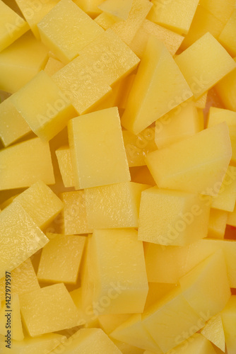 Obraz na płótnie A close-up, top-down shot shows a jumbled pile of raw, light yellow diced potatoes w salonie