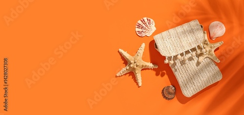 Fototapeta Naklejka Na Ścianę i Meble -  Composition with stylish beach bag and sea shells on orange background with space for text
