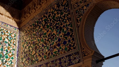 Sunlight moving across ornate tiles and arches in alcazar of seville palace