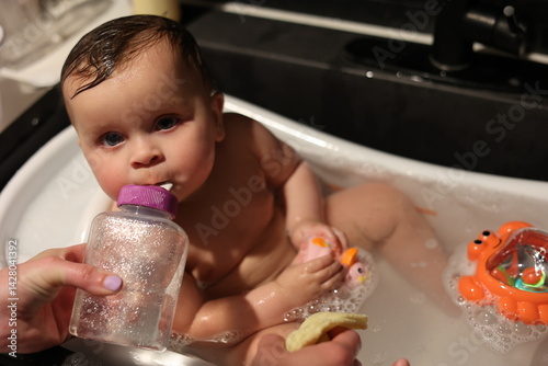 Cute Baby in bath with rubber ducky. 
