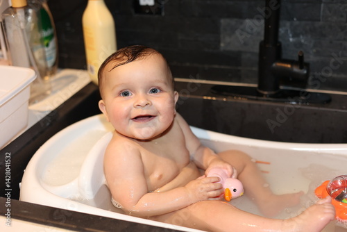 Cute Baby in bath with rubber ducky. 