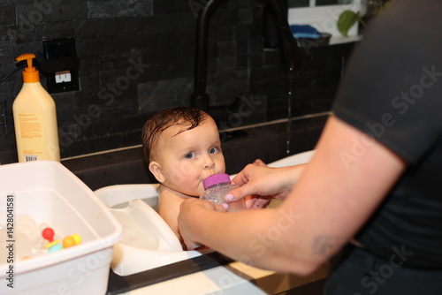 Cute Baby in bath with rubber ducky. 