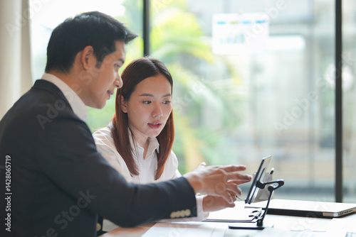 Asian office employee supervising Mentor training trainee at office