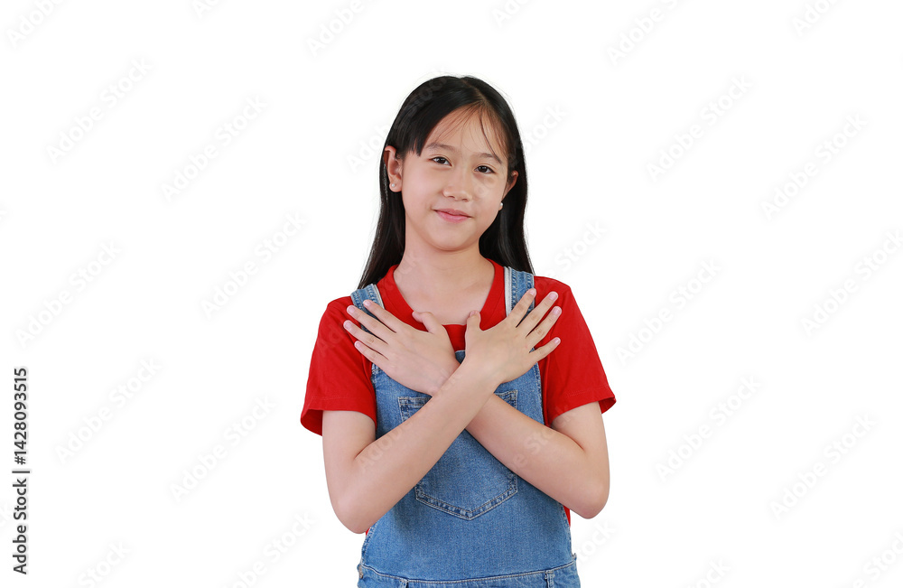 Portrait of smiling Asian girl child hugging herself holds hands on chest gesture on white background. Kid place arms on heart gesture of love.