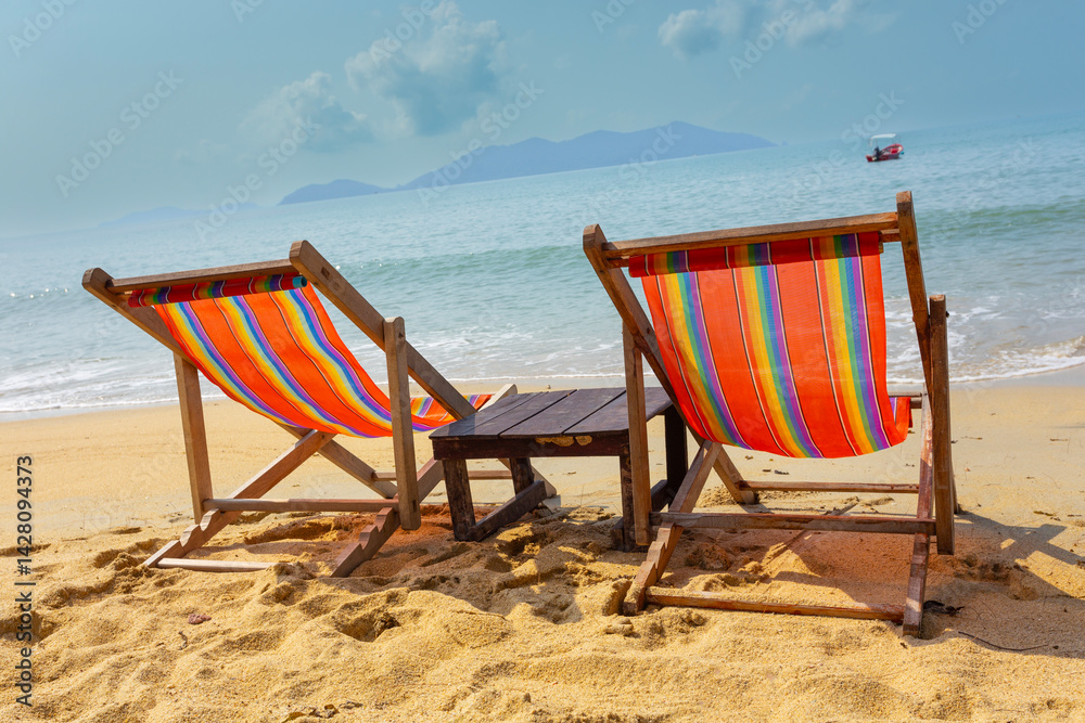sun beach chairs on shore near sea.