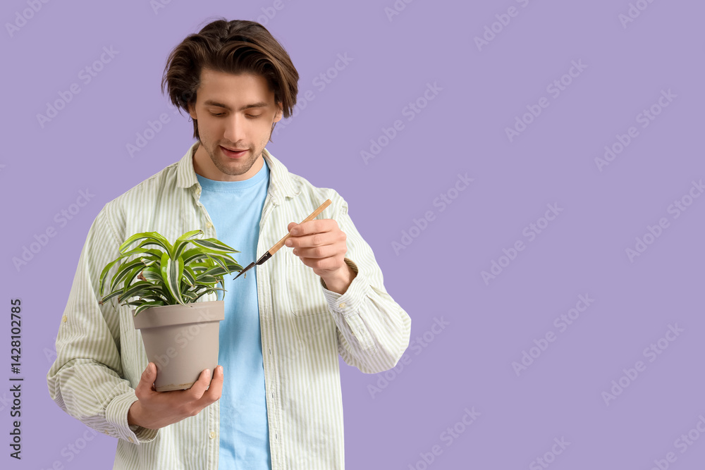 Handsome man with shovel and plant on lilac background Handsome man with shovel and plant on lilac background