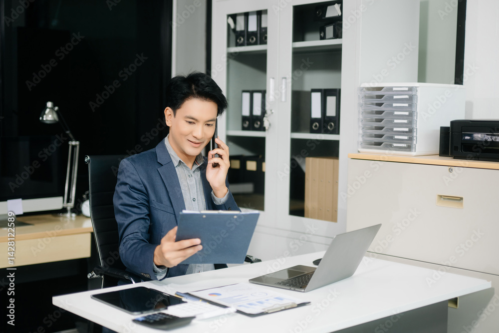Confident businessman working on finance analysis with a tablet and laptop at office desk. Confident businessman working on finance analysis with a tablet and laptop at office desk.