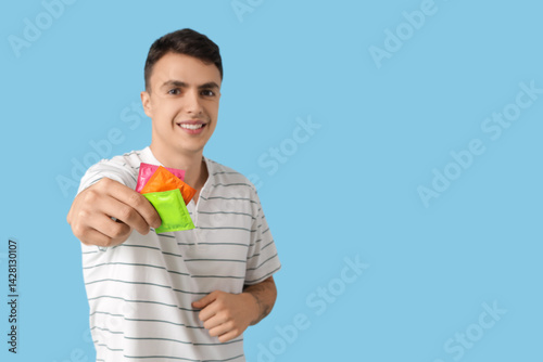 Young man showing condoms o...