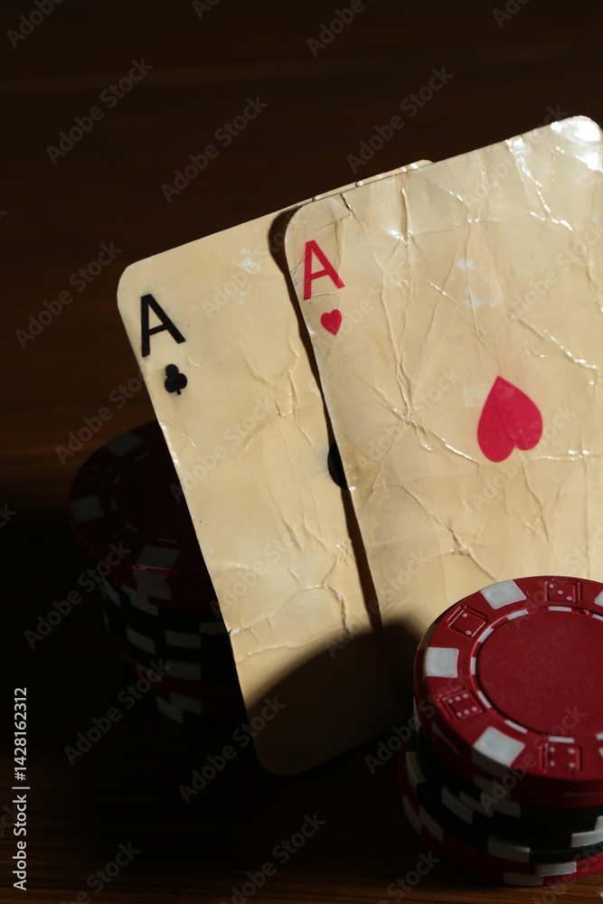 Old vintage playing cards and poker chips on table, closeup