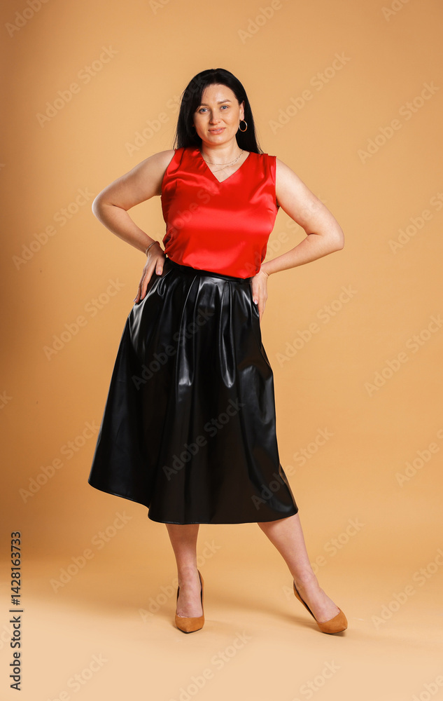 Fototapeta premium Charming plus size model on beige background. Overweight