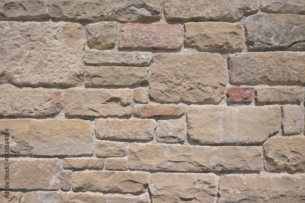 Fototapeta premium Background with a wall of well-carved brown stones