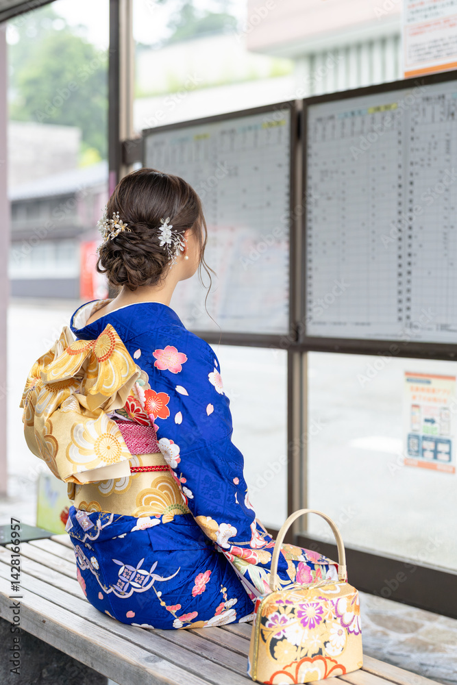 It's a rainy summer day. bus stop. A Japanese woman in a teenager wearing a blue kimono folded and placed it by her side, sitting on a bench.