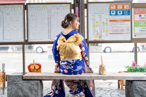 Obraz na płótnie It's a rainy summer day. bus stop. A Japanese woman in a teenager wearing a blue kimono folded and placed it by her side, sitting on a bench. w salonie