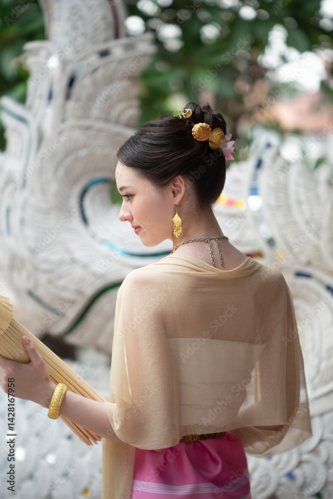 Beautiful young Asean woman in traditional Thai Dvaravati dress in an old temple in Chiang Mai, Thailand.