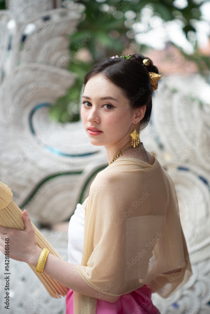 Beautiful young Asean woman in traditional Thai Dvaravati dress in an old temple in Chiang Mai, Thailand.