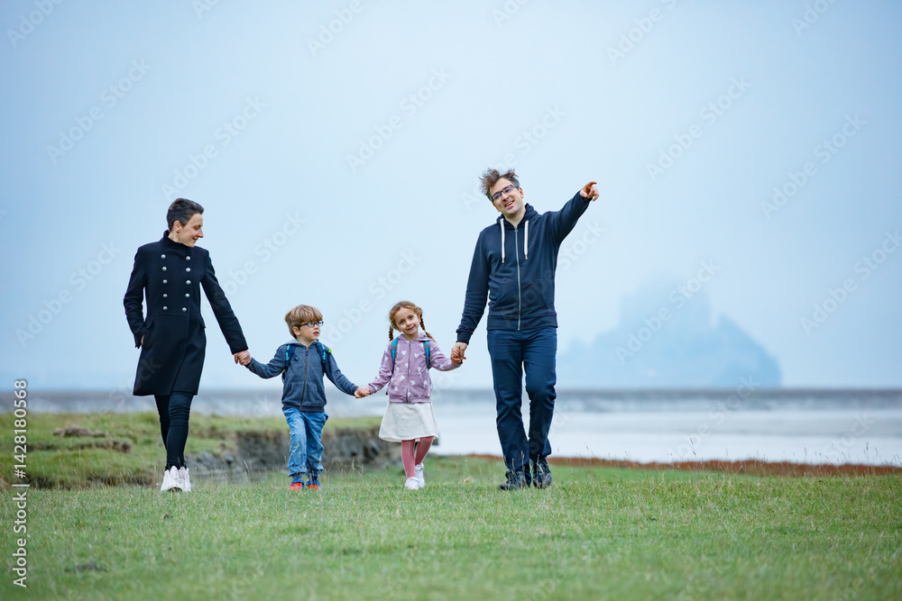 Family enjoys travel in France, Mont Saint-Michel on backdrop