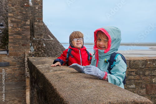 Obraz na płótnie Siblings kids smiling at a seaside fortress Mont Saint Michel w salonie