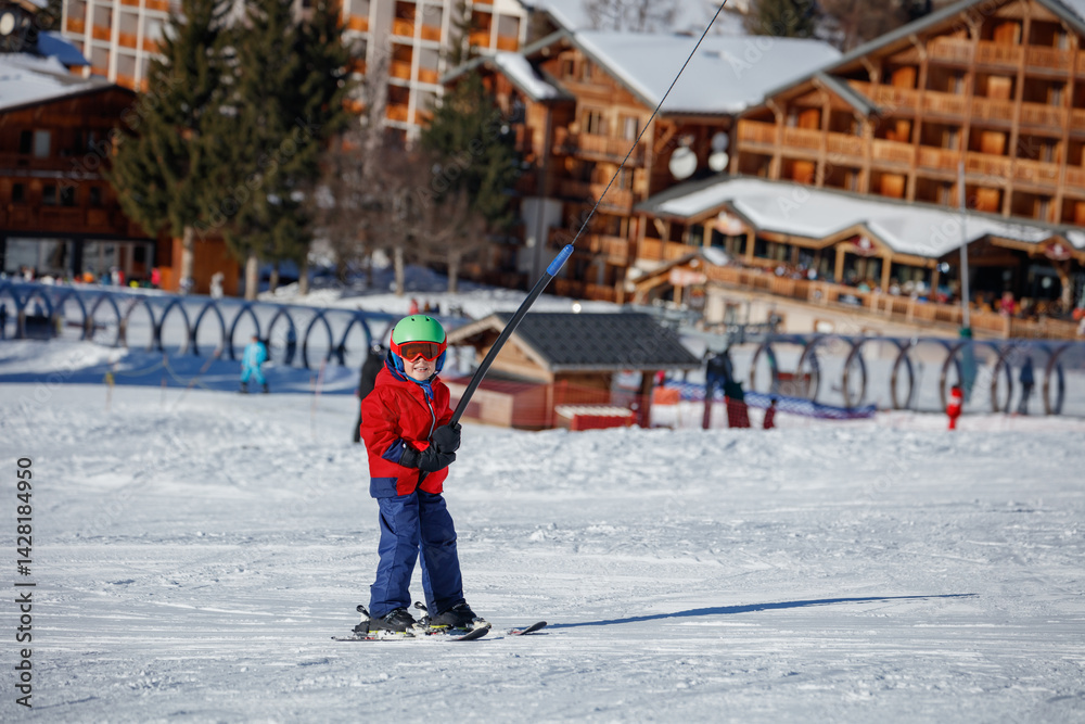 Child ski in colorful attire among breathtaking snowy mountains